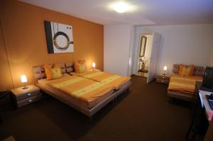ein Hotelzimmer mit 2 Betten und einem TV in der Unterkunft Hôtel de la Croix-Blanche in Cressier