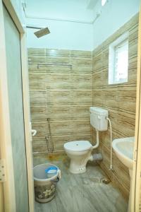 a bathroom with a toilet and a sink at Hotel Tricon Residency in Guwahati