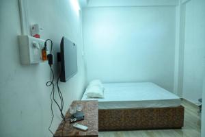 a small room with a bed and a tv at Hotel Tricon Residency in Guwahati