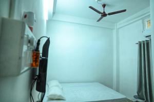 a room with a ceiling fan and a bed at Hotel Tricon Residency in Guwahati