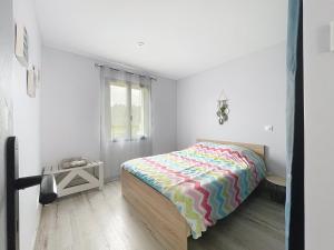 een slaapkamer met een bed met een kleurrijk dekbed bij Maison Lahourcade in Lahourcade