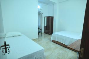 a bedroom with two beds and a blue light at Hotel Tricon Residency in Guwahati