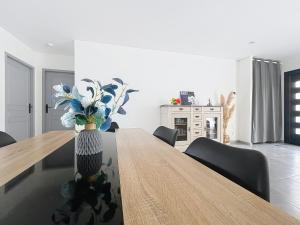 een eetkamer met een tafel met een vaas met bloemen bij Maison Lahourcade in Lahourcade