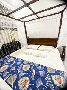 Una cama con un edredón azul y blanco. en Lyra Mirissa, en Mirissa