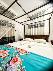 Un dormitorio con una cama con una manta azul. en Lyra Mirissa, en Mirissa