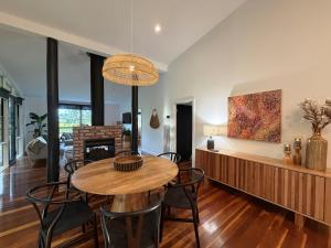 een woonkamer met een tafel, stoelen en een open haard bij Vineyard Cottage at Oakdene in Wallington