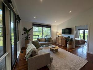 een woonkamer met een bank en een tafel bij Vineyard Cottage at Oakdene in Wallington
