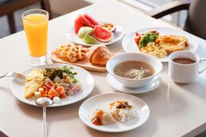 a table topped with plates of food and drinks at Hotel COZZI Ximen Tainan in Tainan