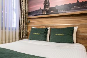 ein Schlafzimmer mit einem Bett mit zwei grünen Kissen in der Unterkunft The Pera Hotel in Istanbul
