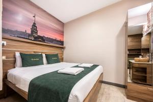 ein Schlafzimmer mit einem großen Bett und einer grünen Decke in der Unterkunft The Pera Hotel in Istanbul