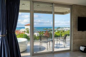 a balcony with sliding glass doors with a view of the ocean at Emerald Ocean Villa in Onna