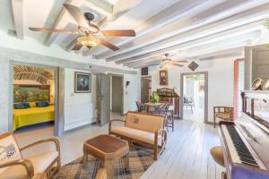 Una sala de estar con ventilador de techo y un piano. en La Casona Del Tio Pedro, en Cadalso de los Vidrios