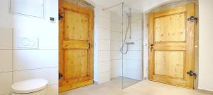 a bathroom with a toilet and a wooden door at Moderne EG-Altbau-Ferienwohnung in Herrnhut in Herrnhut