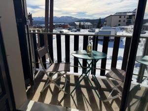 a small table and two chairs on a balcony at STUDIO LES JONQUILLES in Les Angles