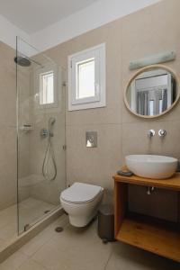 een badkamer met een douche, een toilet en een wastafel bij Vavoulas Village in Mikri Vigla