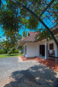 Private Pool Villa in Thodupuzha- Heliconia Inn في Thodupuzha: بيت ابيض صغير بسقف احمر