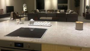 a kitchen with a counter top with a living room at Al Ain Farm Escape with Private Pool , Mini Golf , and Firepit in Bin Aḩmad