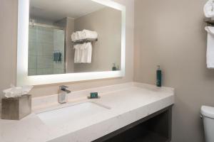 Un baño con un gran espejo y un lavabo. en DoubleTree by Hilton Providence Airport Warwick, en Warwick 27 fotos más