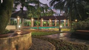 Private Pool Villa in Thodupuzha- Heliconia Inn في Thodupuzha: منتجع به حمام سباحة في الليل +65 صورة