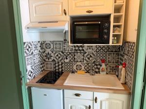 a small kitchen with a sink and a microwave at STUDIO LES JONQUILLES in Les Angles