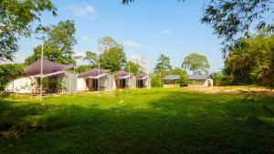 a house in the middle of a green field at Hilir Hening Glamping in Batu Caves
