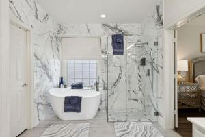 baño con bañera y pared de mármol en Modern 6BR Luxury Villa - Theater, Games, Peloton & EV, en McKinney 54 fotos más