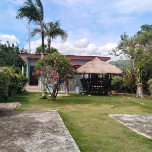 a house with a chair and a straw umbrella at M-J Room Rental in Alcoy