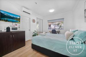 a bedroom with a large bed and a kitchen at Waterfront Studio Room Near City Stadium & Ferry in Townsville in Townsville +6 photos