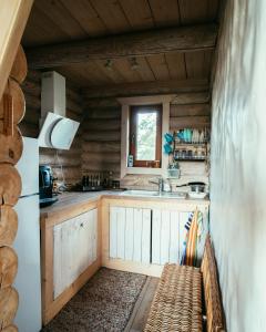a kitchen in a log cabin with a bench at Romantic stay at loghouse VäikeTeeMaja in Üksnurme