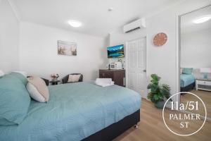 a bedroom with a blue bed and a mirror at Waterfront Studio Room Near City Stadium & Ferry in Townsville in Townsville