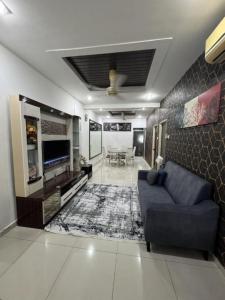 a living room with a blue couch and a tv at D' Mutiara Homestay in Simpang Ampat