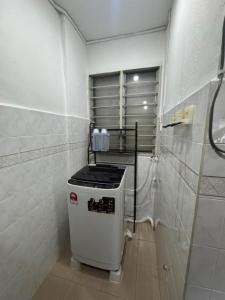 a small kitchen with a stove in a bathroom at D' Mutiara Homestay in Simpang Ampat