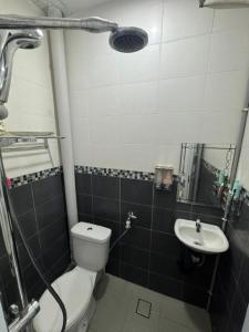 a bathroom with a toilet and a sink at D' Mutiara Homestay in Simpang Ampat
