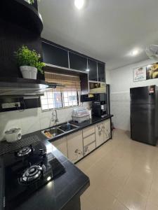 a kitchen with a stove and a sink in it at D' Mutiara Homestay in Simpang Ampat +7 photos