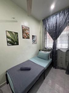 a small bed in a room with a window at D' Mutiara Homestay in Simpang Ampat