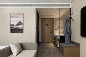 ein Wohnzimmer mit einem Sofa und einem Waschbecken in einem Zimmer in der Unterkunft 上海静安寺西康路亚朵酒店 in Shanghai + 29 Fotos