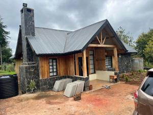 a stone house with a black roof at The T Cottage in Othaya +18 photos