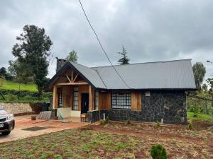 a small house with a car parked in front of it at The T Cottage in Othaya