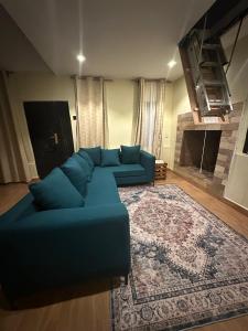 a blue couch in a living room with a rug at The T Cottage in Othaya