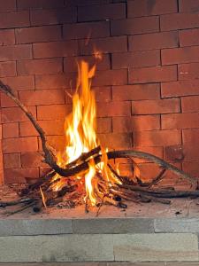 a fire burns in front of a brick wall at The T Cottage in Othaya