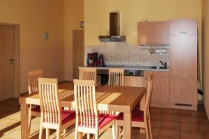 Holiday home in Markkleeberg near a lake في مارك كليبرغ: مطبخ مع طاولة طعام وكراسي خشبية