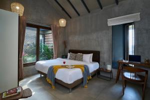 a bedroom with a large white bed and a window at SaffronStays Ashfield - 5BHK Eco-Farmhouse with Pools, Jacuzzi, Lawn & Games Room in Nashik