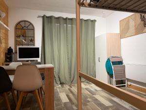 a room with a desk with a computer and a monitor at STUDIO LES JONQUILLES in Les Angles