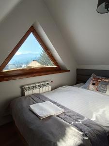 a bed in a room with a large window at Willa Zielona Polana in Czarna Góra