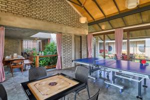 a ping pong room with two ping pong tables at SaffronStays Ashfield - 5BHK Eco-Farmhouse with Pools, Jacuzzi, Lawn & Games Room in Nashik
