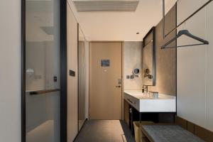 ein Badezimmer mit Waschbecken und Spiegel in der Unterkunft 上海静安寺西康路亚朵酒店 in Shanghai