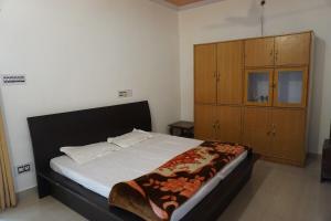 a bedroom with a large bed and a wooden cabinet at Guler House in Jāmb