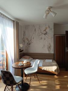 a bedroom with a bed and a table and chairs at Willa Zielona Polana in Czarna Góra