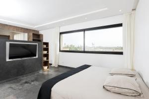 a bedroom with a large bed and a large window at Prestige home in Et Tnine Oudaya