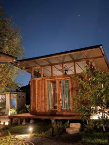 una casa in legno con una grande finestra di San Kue Village - Chiang Mai Pool Villas a Chiang Mai